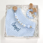 Caja regalo Bebé compuesta por : Bandana de piqué waffle y rizo algodón, realizado a mano con cierre de velcro muy cómodo para su ajuste y seguro a la vez, el algodón waffle es una tela muy suave,manejable y cómoda, tremendamente esponjosa adquiere su nombre por los cuadraditos en relieve, que hacen la forma de un gofre o bien de un nido de abeja. Certificación OEKO-TEX STANDARD 100 apto para articulos que puedan estar en contacto directo con la piel para bebes y niñ@s de hasta tres años. Medidas.- 29cm x 15cm Personalizada con el nombre del bebé Color Azul celeste Sujetachupete silicona de grado alimentario libre de BPA, PVC, Ftalatos, cadmio y plomo. Pinza de madera y cordón de nylon de alta resistencia,bajo normativa europea EN12586:2007 (A1:2011) Personalizado con el nombre del bebé Color Azul celeste Mordedor de silicona de grado alimentario libre de BPA, PVC, Ftalatos, cadmio y plomo. Cordón de nylon de alta resistencia,bajo normativa europea EN12586:2007 (A1:2011) con figura de madera natural de haya. Color Azul celeste