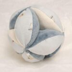 Pelota Montessori Sailors Bay Esta bola de agarre con su forma interesante es un gran desafío para su pequeño. Hay muchos lugares para agarrar y explorar con diferentes texturas y patrones. Es fácil de levantar para las manos pequeñas y cuando se mueve, el alegre sonido de la campana animará a su bebé. Su bonita decoración de veleros y faros, los nudos fáciles de agarrar y las diversas etiquetas estimularán los sentidos, desarrollarán el agarre y mantendrán a su bebé ocupado en el parque. Medidas 12 x 12 x 12cm