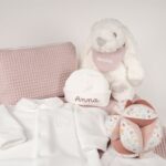 Canastilla bebé Dulces sueños compuesta por : Conejito de peluche BUNNY Peluche fabricado por Artesavi hecho a mano y confeccionado utilizando materiales de la más alta calidad, sus superficies son lavables. Este producto dispone de los ensayos de laboratorio y certificados según normativa Europea EN71-1 / EN71-2 / EN71-3 , estando exentos de tintes tóxicos y partes peligrosas garantizando así la total seguridad para los más pequeños. Medida : 32cm Personalizada la bandana con el nombre del bebé. Pelele manga larga aterciopelado, éste pijama además de estar diseñado especialmente para el descanso del bebé, mantiene la temperatura corporal del bebé al tiempo que se adapta perfectamente a su cuerpo lo que garantiza su comodidad durante el descanso. Composición : terciopelo 80% algodón y 20% polyester Gorrito bebé de algodón, personalizado mediante bordado. Pelota Montessori Flores & Mariposas Esta bola de agarre con su forma interesante es un gran desafío para su pequeño. Hay muchos lugares para agarrar y explorar con diferentes texturas y patrones. Es fácil de levantar para las manos pequeñas y cuando se mueve, el alegre sonido de la campana animará a su bebé. Su bonita decoración de veleros y faros, los nudos fáciles de agarrar y las diversas etiquetas estimularán los sentidos, desarrollarán el agarre y mantendrán a su bebé ocupado en el parque. Medidas 12 x 12 x 12cm Manta de piqué waffle algodón Manta ligera de piqué waffle y forro de coralina, ligera, calentita, fácil de plegar y limpiar. La coralina está fabricada con un innovador y renovado tejido polar, un moderno textil que le ofrece mejores propiedades térmicas. Se caracteriza por su tacto sedoso, textura muy suave, aspecto brillante, y mantener mejor el calor del bebé. Su tacto suave y agradable ofrece al bebé la opción de estar siempre junto a un peluche. Medidas aprox. : 70x100 cm Personalizable Precioso neceser bebé personalizable con la inicial o nombre del bebé