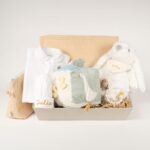 Canastilla bebé Dulces sueños compuesta por : Conejito de peluche BUNNY Peluche fabricado por Artesavi hecho a mano y confeccionado utilizando materiales de la más alta calidad, sus superficies son lavables. Este producto dispone de los ensayos de laboratorio y certificados según normativa Europea EN71-1 / EN71-2 / EN71-3 , estando exentos de tintes tóxicos y partes peligrosas garantizando así la total seguridad para los más pequeños. Medida : 32cm Personalizada la bandana con el nombre del bebé. Pelele manga larga aterciopelado, éste pijama además de estar diseñado especialmente para el descanso del bebé, mantiene la temperatura corporal del bebé al tiempo que se adapta perfectamente a su cuerpo lo que garantiza su comodidad durante el descanso. Composición : terciopelo 80% algodón y 20% polyester Gorrito bebé de algodón, personalizado mediante bordado. Cubo blandito de actividades de Little Dutch, este suave cubo de actividades contiene muchas actividades que estimulan los sentidos del bebé. Hay mucho por descubrir y jugar: varias etiquetas, diferentes texturas, un espejo y un sonajero que suena con cada movimiento. También hay una pequeña rana a la que le gusta jugar al escondite. Este juguete asegura momentos divertidos en el parque. Medidas : 15 x 15 x 15 cm Manta de piqué waffle algodón Manta ligera de piqué waffle y forro de coralina, ligera, calentita, fácil de plegar y limpiar. La coralina está fabricada con un innovador y renovado tejido polar, un moderno textil que le ofrece mejores propiedades térmicas. Se caracteriza por su tacto sedoso, textura muy suave, aspecto brillante, y mantener mejor el calor del bebé. Su tacto suave y agradable ofrece al bebé la opción de estar siempre junto a un peluche. Medidas aprox. : 70x100 cm Personalizable Precioso neceser bebé personalizable con la inicial o nombre del bebé donde podrás poner las cositas necesarias para su aseo, tanto si vas de paseo como de viaje. Neceser de piqué waffle