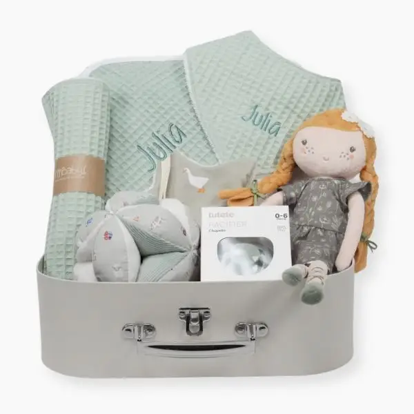 Canastilla Julia compuesta por : Julia, esta muñeca blandita con su bonito vestido desea que la abraces y que juegues con ella, Julia será tu mejor amiga. Ella siempre estará ahí cuando quieras jugar o necesites un buen abrazo. Medida : 35 cm Toalla capa de baño personalizada de waffle 100% algodón orgánico, producido por Hi Baby! Medidas 75 x 75 cm Chupetero de tela pequeños gansos de Hi Baby! 15cm x 15cm., el chupetero es muy suave y agradable para abrazarlo y jugar. Es más fácil encontrar el chupete cuando se ha caído o en la bolsa de pañales. La cinta facilita la sujeción del chupete al chupetero. Parte delantera de tela y parte trasera de tejido de peluche muy suave.Lavable a máquina. Tejido exterior 100% algodón, interior poliéster. Chupete retro nordic personalizado Los chupetes Retro Nordic están equipados con tetina patentada NGermany, sinónimo de alta calidad y de una experiencia de más de 30 años. Todas las tetinas disponen de una válvula que les permite recuperar inmediatamente su forma original. La arandela del chupete Retro Nordic cuenta con un sistema de ventilación que permite que el aire circule entre el chupete y la cara del bebé, evitando marcas y rozaduras. Características 100% BPA FREE Con capucha de protección. Producto Europeo, cumple con la normativa EN1400. Las tetinas de silicona hay que revisarlas a menudo cuando los niños tienen dientes. Personalizado con el nombre del bebé. Bandana de piqué waffle y algodón, realizado a mano con cierre de velcro muy cómodo para su ajuste y seguro a la vez, el algodón waffle es una tela muy suave,manejable y cómoda, tremendamente esponjosa adquiere su nombre por los cuadraditos en relieve, que hacen la forma de un gofre o bien de un nido de abeja. Certificación OEKO-TEX STANDARD 100 apto para articulos que puedan estar en contacto directo con la piel para bebes y niñ@s de hasta tres años. Medidas.- 29cm x 15cm Personalizada con el nombre del bebé. Paño de lactanc