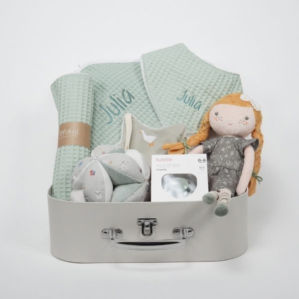 Canastilla Julia compuesta por : Julia, esta muñeca blandita con su bonito vestido desea que la abraces y que juegues con ella, Julia será tu mejor amiga. Ella siempre estará ahí cuando quieras jugar o necesites un buen abrazo. Medida : 35 cm Toalla capa de baño personalizada de waffle 100% algodón orgánico, producido por Hi Baby! Medidas 75 x 75 cm Chupetero de tela pequeños gansos de Hi Baby! 15cm x 15cm., el chupetero es muy suave y agradable para abrazarlo y jugar. Es más fácil encontrar el chupete cuando se ha caído o en la bolsa de pañales. La cinta facilita la sujeción del chupete al chupetero. Parte delantera de tela y parte trasera de tejido de peluche muy suave.Lavable a máquina. Tejido exterior 100% algodón, interior poliéster. Chupete retro nordic personalizado Los chupetes Retro Nordic están equipados con tetina patentada NGermany, sinónimo de alta calidad y de una experiencia de más de 30 años. Todas las tetinas disponen de una válvula que les permite recuperar inmediatamente su forma original. La arandela del chupete Retro Nordic cuenta con un sistema de ventilación que permite que el aire circule entre el chupete y la cara del bebé, evitando marcas y rozaduras. Características 100% BPA FREE Con capucha de protección. Producto Europeo, cumple con la normativa EN1400. Las tetinas de silicona hay que revisarlas a menudo cuando los niños tienen dientes. Personalizado con el nombre del bebé. Bandana de piqué waffle y algodón, realizado a mano con cierre de velcro muy cómodo para su ajuste y seguro a la vez, el algodón waffle es una tela muy suave,manejable y cómoda, tremendamente esponjosa adquiere su nombre por los cuadraditos en relieve, que hacen la forma de un gofre o bien de un nido de abeja. Certificación OEKO-TEX STANDARD 100 apto para articulos que puedan estar en contacto directo con la piel para bebes y niñ@s de hasta tres años. Medidas.- 29cm x 15cm Personalizada con el nombre del bebé. Paño de lactanc