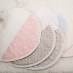Babero redondo de rizo y piqué personalizable, la parte posterior realizada con tejido impermeable. Colores azul, rosa, beige, gris en liso y tambien disponibles con figuras como estrellas, puntos y lineas.