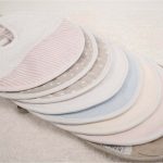 Babero redondo de rizo y piqué personalizable, la parte posterior realizada con tejido impermeable. Colores azul, rosa, beige, gris en liso y tambien disponibles con figuras como estrellas, puntos y lineas.