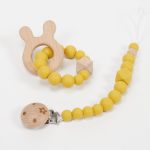 Conjunto chupetero y mordedor silicona MOMMA. Sujetachupete silicona de grado alimentario libre de BPA, PVC, Ftalatos, cadmio y plomo. Pinza de madera y cordón de nylon de alta resistencia,bajo normativa europea EN12586:2007 (A1:2011) Mordedor de silicona de grado alimentario libre de BPA, PVC, Ftalatos, cadmio y plomo. Cordón de nylon de alta resistencia,bajo normativa europea EN12586:2007 (A1:2011) con figura de madera.