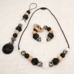 Conjunto compuesto por mordedor de silicona con aro de madera de haya natural, collar de lactancia de madera de haya y silicona y chupetero con pinza de silicona antibacteriana y piezas de silicona de grado alimentario libre de BPA, PVC, Ftalatos, cadmio y plomo con cordón de nylon de alta resistencia, bajo normativa europea EN12586:2007 (A1:2011) Cierre de seguridad con facil apertura. Medida aprox. 35cm Colores etnicos