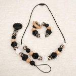 Conjunto compuesto por mordedor de silicona con aro de madera de haya natural, collar de lactancia de madera de haya y silicona y chupetero con pinza de silicona antibacteriana y piezas de silicona de grado alimentario libre de BPA, PVC, Ftalatos, cadmio y plomo con cordón de nylon de alta resistencia, bajo normativa europea EN12586:2007 (A1:2011) Cierre de seguridad con facil apertura. Medida aprox. 35cm Colores etnicos
