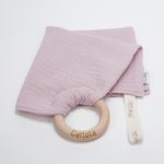Doudou muselina con aro de madera natural de haya personalizado. La muselina es una tela de algodón orgánico muy suave,manejable, cómoda, esponjosa, ligera y agradable al tacto, tambien se denomina gasa de algodón. Todas las telas que utilizamos para el doudou muselina están certificadas con el sello STANDARD 100 by OEKO-TEX® que garantiza la ausencia de sustancias nocivas en el producto, esencial para el contacto directo con la piel para bebes y niñ@s de hasta tres años. Doudou muselina de doble capa, las medidas son 30cm x 30cm. Será uno de sus juguetes favoritos a modo de doudou. Para los más pequeños es muy fácil cogerlo, agarrarlo con fuerza y manejarlo. Calmará al bebé cuando empiece con la dentición. También puede utilizarse como chupetero. Confección artesanal elaborado por Hi Baby!