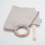 Doudou muselina con aro de madera natural de haya personalizado. La muselina es una tela de algodón orgánico muy suave,manejable, cómoda, esponjosa, ligera y agradable al tacto, tambien se denomina gasa de algodón. Todas las telas que utilizamos para el doudou muselina están certificadas con el sello STANDARD 100 by OEKO-TEX® que garantiza la ausencia de sustancias nocivas en el producto, esencial para el contacto directo con la piel para bebes y niñ@s de hasta tres años. Doudou muselina de doble capa, las medidas son 30cm x 30cm. Será uno de sus juguetes favoritos a modo de doudou. Para los más pequeños es muy fácil cogerlo, agarrarlo con fuerza y manejarlo. Calmará al bebé cuando empiece con la dentición. También puede utilizarse como chupetero. Confección artesanal elaborado por Hi Baby!