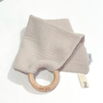 Doudou muselina con aro de madera natural de haya personalizado. La muselina es una tela de algodón orgánico muy suave,manejable, cómoda, esponjosa, ligera y agradable al tacto, tambien se denomina gasa de algodón. Todas las telas que utilizamos para el doudou muselina están certificadas con el sello STANDARD 100 by OEKO-TEX® que garantiza la ausencia de sustancias nocivas en el producto, esencial para el contacto directo con la piel para bebes y niñ@s de hasta tres años. Doudou muselina de doble capa, las medidas son 30cm x 30cm. Será uno de sus juguetes favoritos a modo de doudou. Para los más pequeños es muy fácil cogerlo, agarrarlo con fuerza y manejarlo. Calmará al bebé cuando empiece con la dentición. También puede utilizarse como chupetero. Confección artesanal elaborado por Hi Baby!