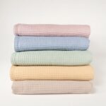 Manta ligera de piqué waffle y forro de coralina, ligera, calentita, fácil de plegar y limpiar. La coralina está fabricada con un innovador y renovado tejido polar, un moderno textil que le ofrece mejores propiedades térmicas. Se caracteriza por su tacto sedoso, textura muy suave, aspecto brillante, y mantener mejor el calor del bebé. Su tacto suave y agradable ofrece al bebé la opción de estar siempre junto a un peluche. Medidas aprox. : 70x100 cm Color: Rosa oscuro, azul oscuro, verde matcha, mostaza y toffe Material y cuidados: Material: Piqué waffle 100% algodón y coralina 100% Polyester Lavar en agua fria maximo a 30°C Tejidos de algodón certificados según la norma OEKO-TEX® 100, clase de producto I