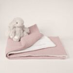 Manta ligera de piqué waffle y forro de coralina, ligera, calentita, fácil de plegar y limpiar. La coralina está fabricada con un innovador y renovado tejido polar, un moderno textil que le ofrece mejores propiedades térmicas. Se caracteriza por su tacto sedoso, textura muy suave, aspecto brillante, y mantener mejor el calor del bebé. Su tacto suave y agradable ofrece al bebé la opción de estar siempre junto a un peluche. Medidas aprox. : 70x100 cm Color: Rosa oscuro Material y cuidados: Material: Piqué waffle 100% algodón y coralina 100% Polyester Lavar en agua fria maximo a 30°C Tejidos de algodón certificados según la norma OEKO-TEX® 100, clase de producto I