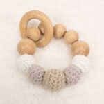 Mordedor de crochet y madera de haya natural libre de BPA, PVC, Ftalatos, cadmio y plomo con cordón de nylon de alta resistencia, bajo normativa europea EN12586:2007 (A1:2011), con aro de madera. Color marrón