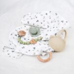 Pack regalo Hi Baby compuesto por Doudou muselina con aro de madera natural de haya, personalizado con el nombre del bebé. La muselina es una tela de algodón orgánico muy suave,manejable, cómoda, esponjosa, ligera y agradable al tacto, tambien se denomina gasa de algodón. Todas las telas que utilizamos para el doudou muselina están certificadas con el sello STANDARD 100 by OEKO-TEX® que garantiza la ausencia de sustancias nocivas en el producto, esencial para el contacto directo con la piel para bebes y niñ@s de hasta tres años. Doudou muselina de doble capa, las medidas son 40cm x 40cm. Será uno de sus juguetes favoritos a modo de doudou. Para los más pequeños es muy fácil cogerlo, agarrarlo con fuerza y manejarlo. Calmará al bebé cuando empiece con la dentición. También se puede sustituir el aro por el chupete, actuando como chupetero. Personalizado el aro de madera con el nombre del bebé, confección artesanal elaborado por Hi Baby! Este guardachupetes bebé de silicona es perfecto para conservar los chupetes limpios hasta su uso, evitar que se pierdan y lo mejor, tenerlos siempre a mano cuando se necesita, con esta funda para chupetes colocada en las asas del cochecito se podrá recuperar rápidamente el chupete de bebé sin tener que buscar en su bolsa. El portachupetes es un accesorio clave y sobretodo muy práctico en cada salida, siendo el lugar ideal para guardar y mantenerlo siempre alejado de gérmenes y bacterias. El portachupetes para bebé es un accesorio esencial para muchos padres, ya que permite llevar y almacenar los chupetes del bebé de manera higiénica y organizada, puede guardar hasta 2 chupetes, y así disponer de un segundo chupete de repuesto, su tamaño compacto permite guardarla en cualquier bolsillo, pero si lo cuelgas del carro, lo agradecerás. Su correa de silicona facilita el transporte y evita que se pierda, puede ser útil para colgar el portachupetes del cochecito, de la bolsa del pañal o la muñeca del adult