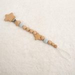 Sujetachupete de haya,madera natural pulida sin barnices con figura de estrella y pinza de madera. Cordón de nylón alta seguridad. Medida 22cm.