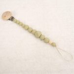 Sujetachupete de silicona de grado alimentario libre de BPA, PVC, Ftalatos, cadmio y plomo. Pinza de madera y cordón de nylon de alta resistencia,bajo normativa europea EN12586:2007 (A1:2011) Color verde matcha