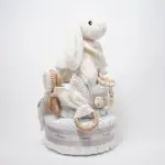 Tarta de pañales de dos pisos compuesta por 44 unidades marca Dodot sensitive, peluche principal conejito con bandana personalizada , mordedor orejitas de piqué waffle, algodón y madera personalizado, sujeta chupetes de silicona personalizado, cepillo y peine para bebé de madera 100% natural personalizados, bandana de piqué waffle y algodón, mordedor de silicona y madera, dou dou animalito. Dimensiones altura 45cm x 26cm ancho.