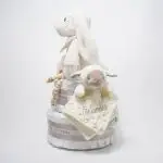 Tarta de pañales de dos pisos compuesta por 44 unidades marca Dodot sensitive, peluche principal conejito con bandana personalizada , mordedor orejitas de piqué waffle, algodón y madera personalizado, sujeta chupetes de silicona personalizado, cepillo y peine para bebé de madera 100% natural personalizados, bandana de piqué waffle y algodón, mordedor de silicona y madera, dou dou animalito. Dimensiones altura 45cm x 26cm ancho.