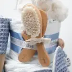 Tarta de pañales 3 pisos SPECIAL CAKE compuesto por 52 unidades marca Dodot sensitive, peluche principal conejito personalizado, sujeta chupetes de silicona Momma, mordedor orejitas piqué waffle algodón con aro de madera personalizado con el nombre del bebé, cepillo y peine para bebé de madera 100% natural personalizado con el nombre del bebé, mordedor de silicona Momma, bandana de piqué waffle y Doudou animalito personalizado con el nombre del bebé. Dimensiones altura 55cm x 26cm ancho. Color Azul Jean.