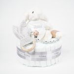 Tarta de pañales 1 piso LITTLE BUNNY compuesto por 28 unidades marca Dodot Sensitive T2, peluche principal conejito personalizado, mordedor de piqué waffle de algodón y aro de madera personalizado, sujeta chupetes de silicona modelo Momma personalizado y juego calcetines bebé de algodón. Dimensiones altura 35cm x 22cm ancho. Color Gris