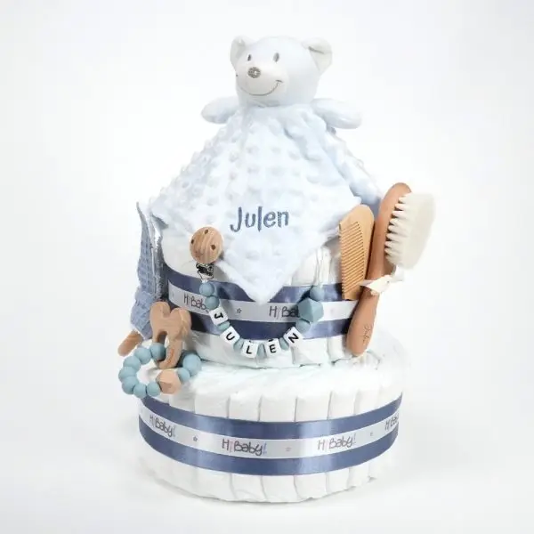 Tarta de pañales 2 pisos BABY DOUDOU compuesta por 44 unidades marca Dodot Sensitive T2, peluche principal Dou Dou personalizado, mordedor orejitas de piqué waffle algodón y madera personalizado, sujeta chupetes de silicona personalizado, cepillo y peine para bebé de madera 100% natural personalizados, mordedor de silicona y madera. Dimensiones altura 40cm x 26cm ancho.
