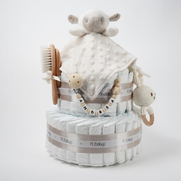 Tarta de pañales 2 pisos BABY RATTLE compuesta por 44 unidades marca Dodot, peluche principal Doudou personalizable, mordedor orejitas de crochet y madera, sujeta chupetes de silicona personalizado, conjunto de cepillo y peine bebé personalizados. Dimensiones altura 40cm x 26cm ancho. Color Beige