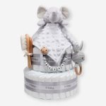 Tarta de pañales 2 pisos BABY RATTLE compuesta por 44 unidades marca Dodot, peluche principal Doudou personalizable, mordedor orejitas de crochet y madera, sujeta chupetes de silicona personalizado, conjunto de cepillo y peine bebé personalizados. Dimensiones altura 40cm x 26cm ancho. Color gris