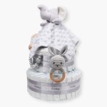 Tarta de pañales 2 pisos BABY RATTLE compuesta por 44 unidades marca Dodot, peluche principal Doudou personalizable, mordedor orejitas de crochet y madera, sujeta chupetes de silicona personalizado, conjunto de cepillo y peine bebé personalizados. Dimensiones altura 40cm x 26cm ancho. Color gris