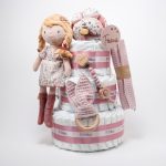 Tarta de pañales de 3 pisos compuesto por 52 unidades marca Dodot sensitive, pelota sensorial Montessori de Little Dutch, mordedor orejitas de tela piqué waffle algodón y aro de madera natural personalizado con el nombre del bebé, bandana de tela piqué waffle algodón personalizable, chupetero de silicona y crochet con pinza de madera natural de haya, paño de lactancia de piqué waffle algodón, muñeca ANNA de Little Dutch 35cm. Stick de madera personalizado con el nombre del bebé. Dimensiones altura 42cm x 27cm ancho. Color Rosa palo