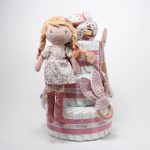Tarta de pañales de 3 pisos compuesto por 52 unidades marca Dodot sensitive, pelota sensorial Montessori de Little Dutch, mordedor orejitas de tela piqué waffle algodón y aro de madera natural personalizado con el nombre del bebé, bandana de tela piqué waffle algodón personalizable, chupetero de silicona y crochet con pinza de madera natural de haya, paño de lactancia de piqué waffle algodón, muñeca ANNA de Little Dutch 35cm. Stick de madera personalizado con el nombre del bebé. Dimensiones altura 42cm x 27cm ancho. Color Rosa palo
