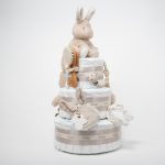 Tarta de pañales Baby Bunny 3 pisos compuesto por 52 unidades marca Dodot sensitive T2, peluche principal conejito colección Baby Bunny, Botitas patucos con estampado colección Baby Bunny, fabricados con algodón 100% orgánico. Chupetero de silicona con pinza de silicona de alta calidad, personalizado con el nombre del bebé, elaborado por Hi Baby , Sonajero anillo conejito de la colección baby bunny, de Little Dutch,Chupetero de tela muselina, colección baby bunny,Doudou muselina baby bunny de Little Dutch,Conjunto cepillo y peine bebé de madera, personalizados con su nombre. Dimensiones altura 48cm x 28cm ancho. Color Beige/Toffe