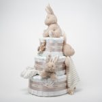Tarta de pañales Baby Bunny 3 pisos compuesto por 52 unidades marca Dodot sensitive T2, peluche principal conejito colección Baby Bunny, Botitas patucos con estampado colección Baby Bunny, fabricados con algodón 100% orgánico. Chupetero de silicona con pinza de silicona de alta calidad, personalizado con el nombre del bebé, elaborado por Hi Baby , Sonajero anillo conejito de la colección baby bunny, de Little Dutch,Chupetero de tela muselina, colección baby bunny,Doudou muselina baby bunny de Little Dutch,Conjunto cepillo y peine bebé de madera, personalizados con su nombre. Dimensiones altura 48cm x 28cm ancho. Color Beige/Toffe