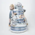 Tarta de pañales de 3 pisos JIMMY compuesto por 52 unidades marca Dodot sensitive, pelota sensorial Montessori de Little Dutch, chupetero de silicona, mordedor de silicona con figura de madera natural de haya, muñeco JIMMY de Little Dutch 35cm., Chupetero muselina buho de Little Dutch, Doudou Sailors bay de Little Dutch, stick de madera personalizado con el nombre del bebé. Dimensiones altura 42cm x 27cm ancho. Color Azul jean