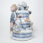 Tarta de pañales de 3 pisos JIMMY compuesto por 52 unidades marca Dodot sensitive, pelota sensorial Montessori de Little Dutch, chupetero de silicona, mordedor de silicona con figura de madera natural de haya, muñeco JIMMY de Little Dutch 35cm., Chupetero muselina buho de Little Dutch, Doudou Sailors bay de Little Dutch, stick de madera personalizado con el nombre del bebé. Dimensiones altura 42cm x 27cm ancho. Color Azul jean