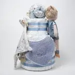 Tarta de pañales de 3 pisos JIMMY compuesto por 52 unidades marca Dodot sensitive, pelota sensorial Montessori de Little Dutch, chupetero de silicona, mordedor de silicona con figura de madera natural de haya, muñeco JIMMY de Little Dutch 35cm., Chupetero muselina buho de Little Dutch, Doudou Sailors bay de Little Dutch, stick de madera personalizado con el nombre del bebé. Dimensiones altura 42cm x 27cm ancho. Color Azul jean