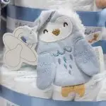 Tarta de pañales de 3 pisos JIMMY compuesto por 52 unidades marca Dodot sensitive, pelota sensorial Montessori de Little Dutch, chupetero de silicona, mordedor de silicona con figura de madera natural de haya, muñeco JIMMY de Little Dutch 35cm., Chupetero muselina buho de Little Dutch, Doudou Sailors bay de Little Dutch, stick de madera personalizado con el nombre del bebé. Dimensiones altura 42cm x 27cm ancho. Color Azul jean