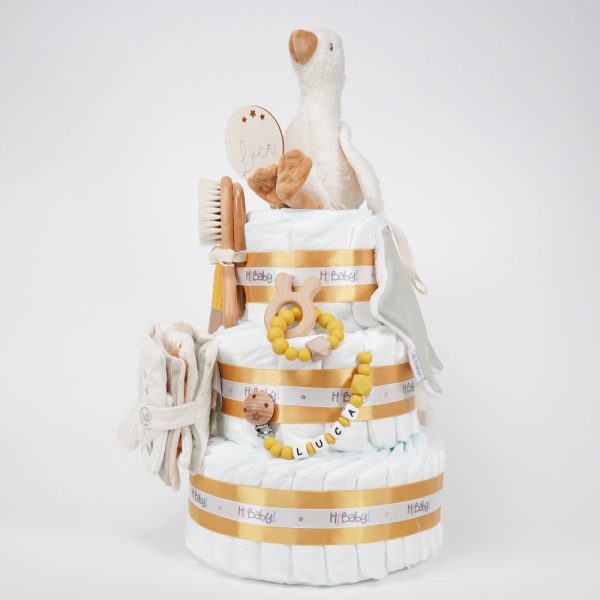 Tarta de pañales de tres pisos compuesto por 52 unidades marca Dodot sensitive, peluche principal pequeña oca de Little Dutch 18cm de altura está hecha de una felpa increiblemente suave ideal para el bebé, chupetero de silicona con pinza de madera personalizado con el nombre del bebé de grado alimentario libre de BPA, PVC, Ftalatos, cadmio y plomo, mordedor de silicona con figura de madera natural haya, paño lactancia de piqué waffle 35cm x 25cm, librito blando de actividades Little Dutch, Doudou oca de Little Dutch personalizado con el nombre del bebé hecho con felpa muy suave aportando comodidad al bebé cuando duerme, dispone de varias etiquetas para tocar y sentir estimulando los sentidos del bebé, los nudos y patas son perfectos para acurrucarse o masticar cuando empiezan a salir los dientes puede actuar como chupetero tiene enganche para chupete medidas 24cm x 24cm, chupetero de tela algodón pequeñas ocas de Hi Baby!15cm x 15cm. Cepillo y peine de madera personalizados con el nombre del bebé. Stick de madera personalizado. Dimensiones altura 50cm x 26cm ancho. Color Mostaza