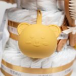 Tarta de pañales de tres pisos compuesto por 52 unidades marca Dodot sensitive, peluche principal Pulpo dorado 40cm, increiblemente suave y decorativo, chupetero de silicona con pinza de silicona de grado alimentario libre de BPA, PVC, Ftalatos, cadmio y plomo, mordedor de silicona con figura de madera natural haya, bandana secababitas de piqué waffle, chupetero de tela estrella de Little Dutch 15cm x 15cm, cepillo y peine personalizados con el nombre del bebé de madera natural, sonajero conejo orejitas de Artesavi 35cm, stick de madera personalizado con el nombre del bebé. Dimensiones altura 45cm x 26cm ancho. Color Melocotón