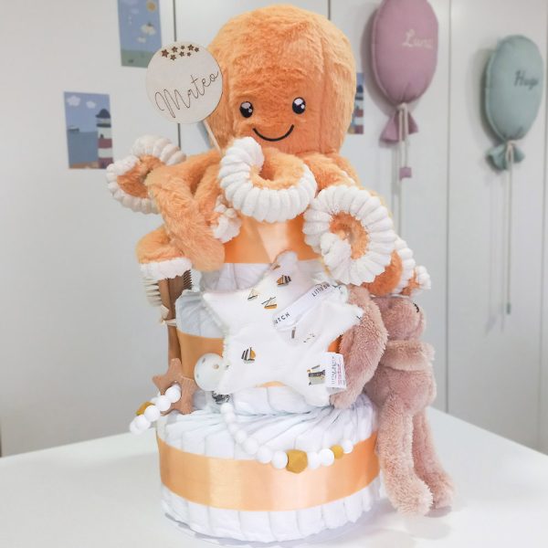 Tarta de pañales de tres pisos pulpito compuesto por 52 unidades marca Dodot sensitive, peluche principal Pulpo dorado 40cm, increiblemente suave y decorativo, chupetero de silicona con pinza de silicona de grado alimentario libre de BPA, PVC, Ftalatos, cadmio y plomo, mordedor de silicona con figura de madera natural haya, bandana secababitas de piqué waffle, chupetero de tela estrella de Little Dutch 15cm x 15cm, cepillo y peine personalizados con el nombre del bebé de madera natural, sonajero conejo orejitas de Artesavi 35cm, stick de madera personalizado con el nombre del bebé. Dimensiones altura 45cm x 26cm ancho. Color Melocotón