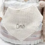 Tarta pañales V. Sunny Champagne compuesto por 84 unidades marca Dodot, peluche principal Mocca de Teddykompaniet 25 cm, chupetero de silicona de grado alimentario libre de BPA, PVC, Ftalatos, cadmio y plomo, bandana secababitas, chupete personalizado, mordedor orejitas y capa de baño de piqué waffle personalizada de Hi Baby, Doudou baby bunny personalizado, conjunto de cepillo y peine de madera personalizado hecho con materiales 100% naturales de lana de cabra y madera de haya, ofreciendo una experiencia cómoda y suave para tu bebé. Ideal para el cuero cabelludo sensible de los más pequeños, guardachupetes de silicona perfecto para guardar el chupete cuando no se está usando, body de babidu personalizado con el dibujo de un conejito y el nombre del bebé. Dimensiones altura 56cm x 30cm ancho. Color Champagne