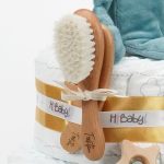Tarta de pañales Baby Lion regalo bebé recién nacido compuesta por.- 44 unidades marca Dodot sensitive T2, peluche principal bebé león, mordedor de silicona con figuras de madera de haya, chupetero de silicona y madera con figurita personalizada, conjunto de cepillo y peine de madera personalizados, chupetero de tela algodón y coralina extrasuave 20cm x 20cm, estampado original Selva. Dimensiones altura 42cm x 26cm ancho. Peluche León apto para +0 meses, producido con tejidos muy suaves y detalles bordados, ojos y nariz, divertido peluche fácil de coger para las manos más pequeñas con certificados adicionales a los obligatorios como los de saliva y exclusión de tintes tóxicos en los tejidos, con la máxima garantía para los mas pequeños. Está fabricado en material de alta calidad muy suave y apto para el bebé. Superficie lavable. Homologación europea EN71-1- Lavado: a mano o máquina a 30° C, Se recomienda utilizar un programa y detergente suave. No utilizar secadora. Medida 32cm. Peso del producto 200 g.