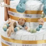 Tarta de pañales Baby Lion 3Pisos regalo bebé recién nacido compuesta por.- 52 unidades marca Dodot sensitive T2, peluche principal bebé león, mordedor de silicona con figuras de madera de haya, chupetero de silicona y madera con figurita personalizada, conjunto de cepillo y peine de madera personalizados, chupetero de tela algodón y coralina extrasuave 20cm x 20cm, estampado original Selva. Sonajero crochet figurita león con aro de madera personalizado con el nombre del bebé, toalla capa de baño Selva de Hi Baby! 100% algodón.medidas 80cm x 80 cm Dimensiones tarta, altura 42cm x 26cm ancho. Peluche León apto para +0 meses, producido con tejidos muy suaves y detalles bordados, ojos y nariz, divertido peluche fácil de coger para las manos más pequeñas con certificados adicionales a los obligatorios como los de saliva y exclusión de tintes tóxicos en los tejidos, con la máxima garantía para los mas pequeños. Está fabricado en material de alta calidad muy suave y apto para el bebé. Superficie lavable. Homologación europea EN71-1- Lavado: a mano o máquina a 30° C, Se recomienda utilizar un programa y detergente suave. No utilizar secadora. Medida 32cm. Peso del producto 200 g.