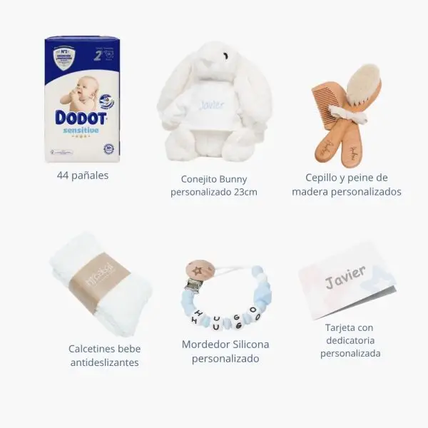 Tarta de pañales de dos pisos compuesta por 44 unidades marca Dodot Sensitive T2, peluche principal conejito personalizado, conjunto cepillo y peine bebé de madera personalizado, sujeta chupetes de silicona personalizado y juego calcetines bebé. Dimensiones altura 45cm x 26cm ancho.