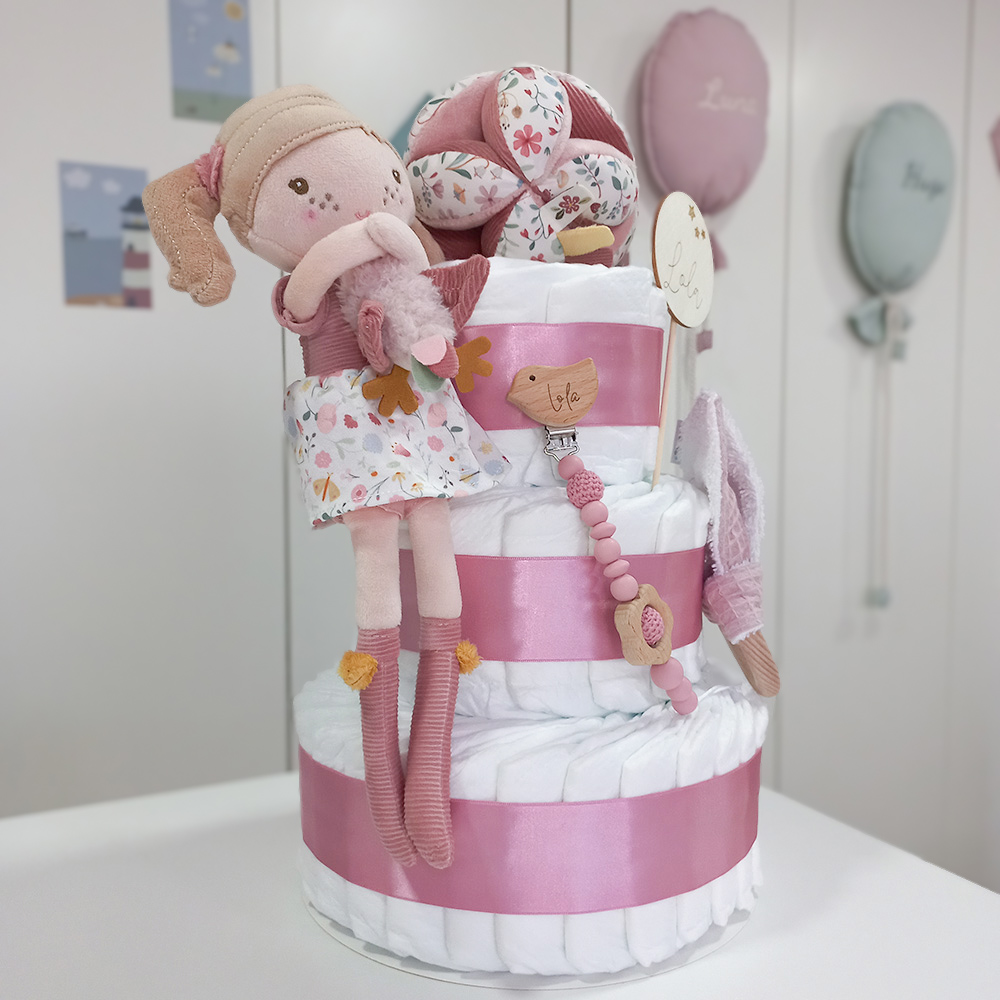 Tarta de pañales de 3 pisos compuesto por 52 unidades marca Dodot sensitive, pelota sensorial Montessori de Little Dutch, mordedor orejitas de tela piqué waffle algodón y aro de madera natural personalizado con el nombre del bebé, bandana de tela piqué waffle algodón personalizable, chupetero de silicona y crochet con pinza de madera natural de haya, paño de lactancia de piqué waffle algodón, muñeca ANNA de Little Dutch 35cm. Stick de madera personalizado con el nombre del bebé. Dimensiones altura 42cm x 27cm ancho. Color Rosa oscuro