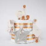 Tarta pañales de 2 pisos compuesto por 44 unidades marca Dodot sensitive, peluche principal pequeña oca de Li ttle Dutch 18cm de altura está hecha con una felpa increiblemente suave ideal para el bebé, Doudou oca personalizado de Little Dutch hecho con felpa muy suave aportando comodidad al bebé, cuando duerme dispone de varias etiquetas para tocar y sentir estimulando los sentidos del bebé los nudos y patas son perfectos para acurrucarse o masticar cuando empiezan a salir los dientes puede actuar como chupetero tiene enganche para chupete medidas 24cm x 24cm, chupetero de tela estrella de Little Dutch 15cm x 15cm. Librito blando actividades Little Dutch, Chupetero de tela algodón pequeños gansos de Hi Baby! Stick de madera personalizado con el nombre del bebé. Dimensiones altura 38cm x 26cm ancho. Color Mostaza