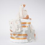 Tarta de pañales de 2 pisos compuesto por 44 unidades marca Dodot sensitive, peluche principal pequeña oca de Li ttle Dutch 18cm de altura está hecha con una felpa increiblemente suave ideal para el bebé, Doudou oca personalizado de Little Dutch hecho con felpa muy suave aportando comodidad al bebé, cuando duerme dispone de varias etiquetas para tocar y sentir estimulando los sentidos del bebé los nudos y patas son perfectos para acurrucarse o masticar cuando empiezan a salir los dientes puede actuar como chupetero tiene enganche para chupete medidas 24cm x 24cm, chupetero de tela estrella de Little Dutch 15cm x 15cm. Librito blando actividades Little Dutch, Chupetero de tela algodón pequeños gansos de Hi Baby! Stick de madera personalizado con el nombre del bebé. Dimensiones altura 38cm x 26cm ancho. Color Mostaza